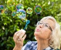 Senior woman blowing bubbles Royalty Free Stock Photo