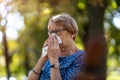 Senior woman blowing her nose Royalty Free Stock Photo