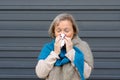 Senior woman blowing her nose on a tissue Royalty Free Stock Photo