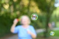 Senior woman blowing iridescent soap bubbles Royalty Free Stock Photo