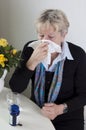 Senior woman blows her nose