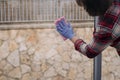 Senior woman in blue gloves cleaning window with pink rag.Housework concept. Closeup photo. Royalty Free Stock Photo