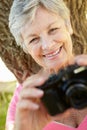 Senior woman with camera smiling Royalty Free Stock Photo