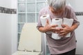 Senior woman carrying holding a lot of toilet paper in bathroom,many rolls of toilet paper for wiping,cleaning after urination or