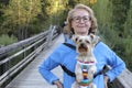 Senior woman carrying small dog in colorful bag