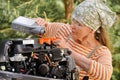 Senior woman changing engine oil Royalty Free Stock Photo