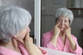 Senior woman checking her puffy eyes out Royalty Free Stock Photo