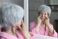 Senior woman checking her puffy eyes out Royalty Free Stock Photo