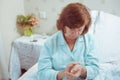 Senior woman checking her pulse sitting on a bed.