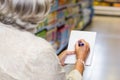 Senior woman checking list at the supermarket Royalty Free Stock Photo