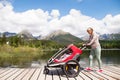 Senior woman and children in jogging stroller, summer day. Royalty Free Stock Photo