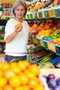 Senior woman choosing oranges in greengrocer Royalty Free Stock Photo