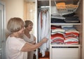 Senior woman choosing outfit from wardrobe. Cleaning, organizing and order in the closet Royalty Free Stock Photo