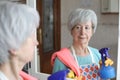 Senior woman cleaning a mirror Royalty Free Stock Photo