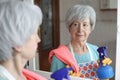 Senior woman cleaning a mirror Royalty Free Stock Photo