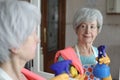 Senior woman cleaning a mirror Royalty Free Stock Photo