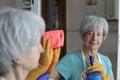 Senior woman cleaning a mirror Royalty Free Stock Photo