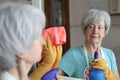 Senior woman cleaning a mirror Royalty Free Stock Photo