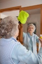 Senior woman cleaning mirror at home Royalty Free Stock Photo