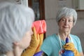 Senior woman cleaning a mirror Royalty Free Stock Photo