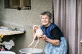 Senior woman cleaning and washing freshly slaughtered chicken. Royalty Free Stock Photo