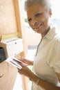 Senior Woman Collecting Letter From Mailbox