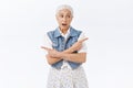 Senior woman consulting with son. Pretty old lady with grey hair, wear denim vest, dress, cross hands chest, pointing Royalty Free Stock Photo