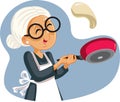 Cheerful Grandmother Flipping Pancakes for Breakfast