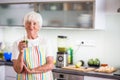 Senior woman cooking in the kitchen - eating and cooking healthy Royalty Free Stock Photo