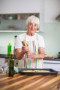 Senior woman cooking in the kitchen - eating and cooking healthy