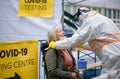 Senior woman in covid-19 testing center outdoors on street, coronavirus and swab taking concept.