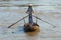 Senior woman crosses Mekong river by a traditional wooden paddleboat in Cai Be, Vietnam.