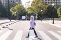 senior woman crossing a street with shopping bags Royalty Free Stock Photo