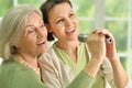 Senior woman with daughter singing on microphone