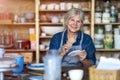 Mature craftswoman painting a plate made of clay in art studio