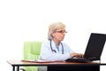 Senior woman doctor typing on laptop