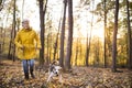 Senior woman with dog on a walk in an autumn forest. Royalty Free Stock Photo