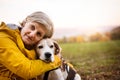 Senior woman with dog on a walk in an autumn nature. Royalty Free Stock Photo