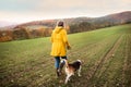 Senior woman with dog on a walk in an autumn nature. Royalty Free Stock Photo