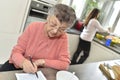 Senior woman doing crosswords waiting for the meal Royalty Free Stock Photo