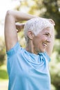 Senior woman doing exercise for stretching hand in the park Royalty Free Stock Photo