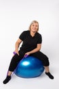 Senior woman doing exercises on a fitness ball and with an elastic band. Photo on a white background Royalty Free Stock Photo