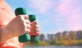 Senior woman doing physical exercise outdoors with dumbbells.  Senior healthcare and sport concept. Copy space Royalty Free Stock Photo