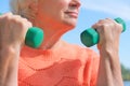 Senior woman doing physical exercise outdoors with dumbbells.  Senior healthcare and sport concept Royalty Free Stock Photo