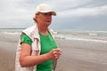 Senior woman doing sport to keep fit. Mature woman running along the shore of the beach. Concept of healthy life in the elderly. Royalty Free Stock Photo