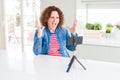 Senior woman doing video chat using smartphone camera crazy and mad shouting and yelling with aggressive expression and arms Royalty Free Stock Photo