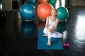 Senior woman Doing yoga in fitness gym. aged lady exercising.  Old female taking a break from  workout .Mature sport training. Royalty Free Stock Photo