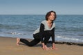 Senior woman doing yoga sun salutation on the beach Royalty Free Stock Photo