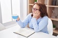 Senior woman drinking coffee reading book at home Royalty Free Stock Photo