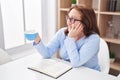 Senior woman drinking coffee reading book at home Royalty Free Stock Photo